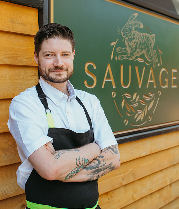 A picture of Chef Bram Ashby in front of Sauvage.